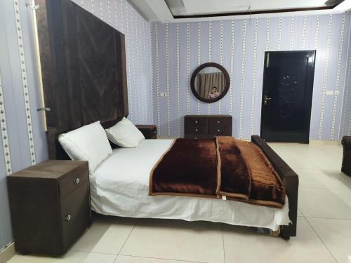 ein Schlafzimmer mit einem großen Bett und einem Spiegel in der Unterkunft Grand Orchard One Hotel in Lahore