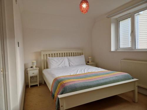 a bedroom with a bed with a rainbow blanket at Broadstairs Hideaway W Parking and Mins to Beach in Broadstairs