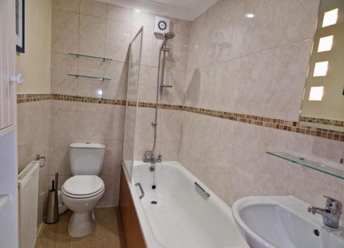 a bathroom with a toilet and a tub and a sink at Broadstairs Hideaway W Parking and Mins to Beach in Broadstairs