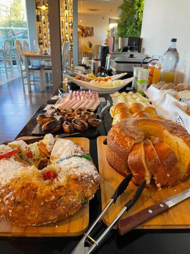 une table avec différents types de pain et de viennoiseries dans l'établissement Hotel A Ponte, à Viana do Castelo