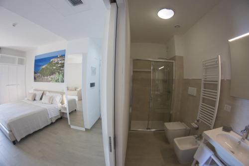 y baño con cama, ducha y lavabo. en Est hotel en Santa Cesarea Terme