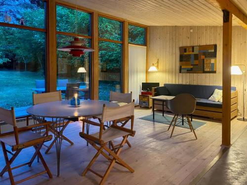 Un comedor y una sala de estar con mesa y sillas. en Architect-Designed Wooden House In Tisvilde Lunde, en Tisvildeleje