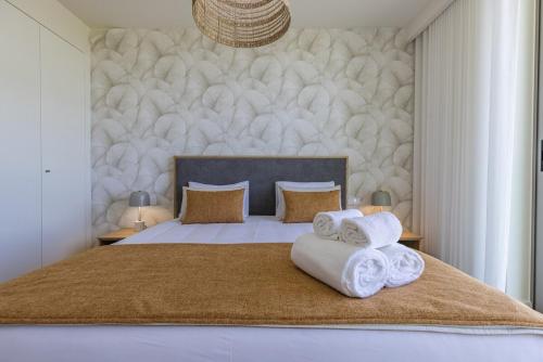 a bedroom with a bed with towels on it at Bayline XV in Armação de Pêra