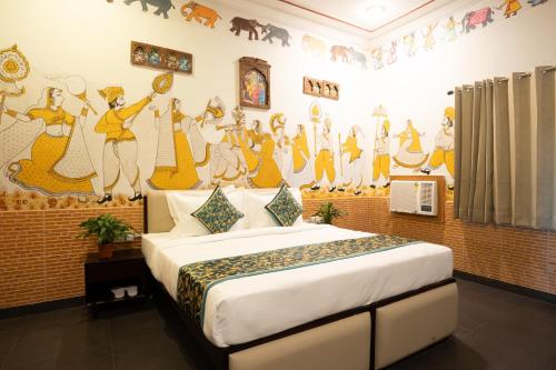 een slaapkamer met een bed met een muurschildering aan de muur bij Stamps By Eight Continents, Pushkar in Pushkar