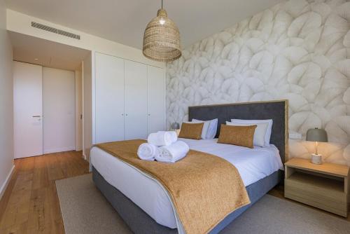 a bedroom with a large bed with towels on it at Bayline XV in Armação de Pêra