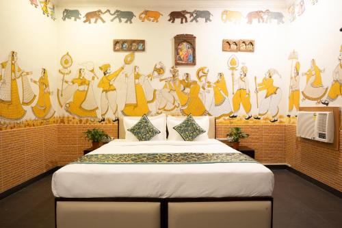 een slaapkamer met een bed met een muurschildering aan de muur bij Stamps By Eight Continents, Pushkar in Pushkar