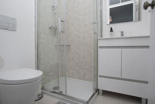 a bathroom with a shower with a toilet and a sink at Belem1886 - Tagus Horizon in Lisbon