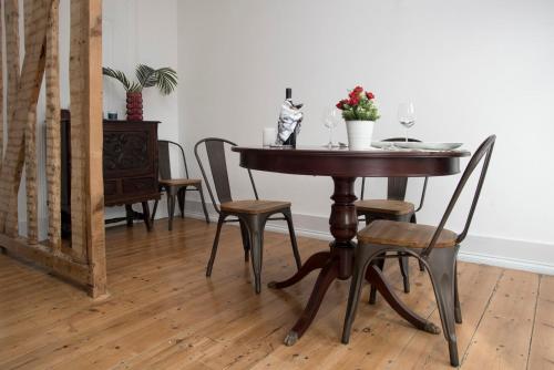a dining room table with chairs and a table with wine glasses at Belem1886 - Tagus Horizon in Lisbon