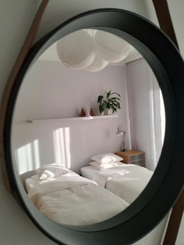 a mirror reflecting two beds in a bedroom at MIKO apartament in Mikołów
