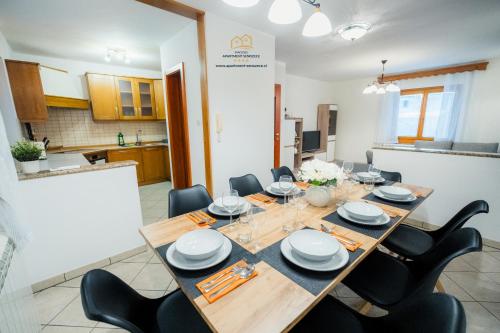 comedor con mesa de madera y sillas negras en Spacious Apartment Senozece - with terrace & grill, en Senožeče