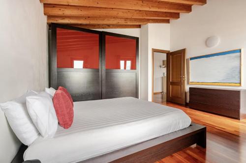 een slaapkamer met een groot wit bed met rode kussens bij Villa Mattei Franciacorta in Villa Pedergnano