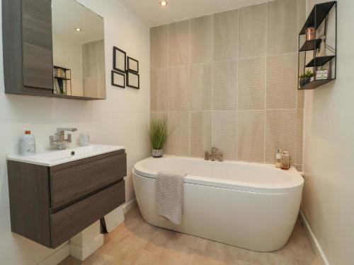 a bathroom with a tub and a sink and a toilet at Lair Close House in Harrogate