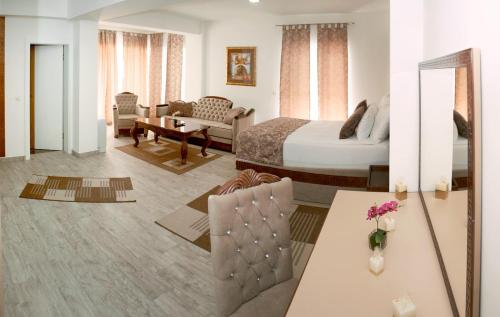 a hotel room with a bed and a living room at Hotel Rekic in Bihać
