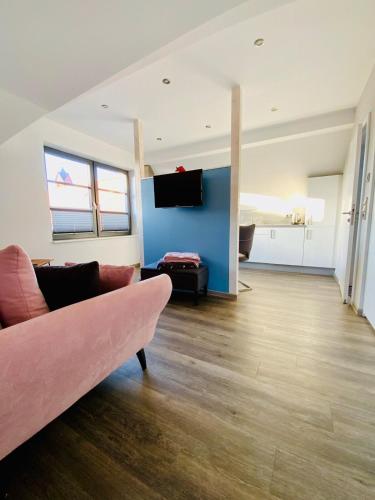 a living room with a couch and a tv at Haus Kalmar in Langeoog