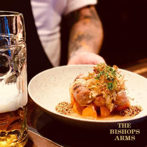 a plate of food on a table next to a glass of beer at Hotel Bishops Arms Kristianstad in Kristianstad