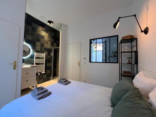 a bedroom with a bed and a sink and a mirror at Le Laurencin Sens - Le Keys - Cœur de ville in Sens