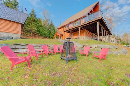 a group of red chairs in front of a house at Le Tresor du Lac in Mandeville