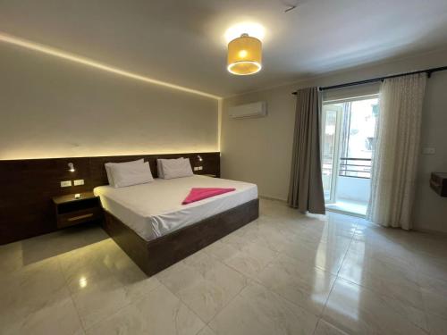 a bedroom with a bed and a large window at Lovely Rivera Room with Breakfast in Cairo
