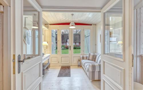 einen Flur mit einem Wohnzimmer mit Sofa und Fenstern in der Unterkunft Gorgeous Home In Galmsbüll in Galmsbüll