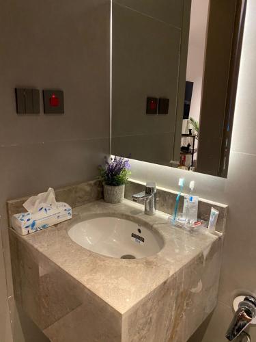 een badkamermeubel met een wastafel en een spiegel bij Velora Serviced Apartments in Al Khobar