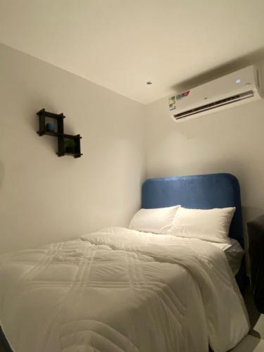 een slaapkamer met een bed met een blauw hoofdeinde bij Velora Serviced Apartments in Al Khobar
