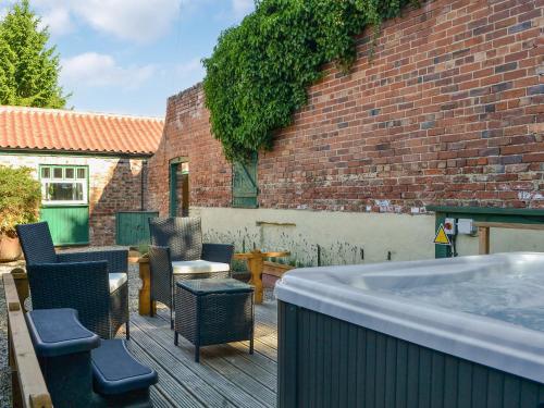 een hot tub op een terras naast een bakstenen gebouw bij Hazels Cottage - Uk40198 in Hayton