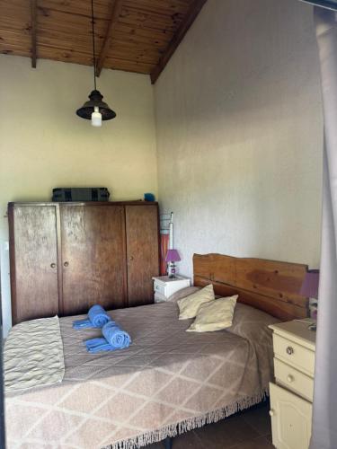 een slaapkamer met een groot bed met blauwe handdoeken bij Cabaña Zara in Villa Yacanto
