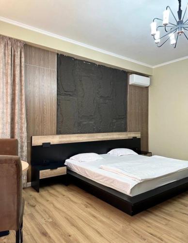a bedroom with a bed and a black wall at Van park hotel in Shymkent