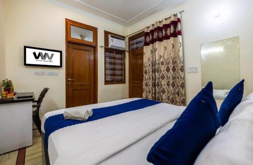 um quarto com uma cama grande com travesseiros azuis em Hotel Emerald Suites & Banquet By Aura em Noida