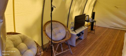 una stanza con due sedie e una tv in una tenda di Kayi glamping a Kaliurang
