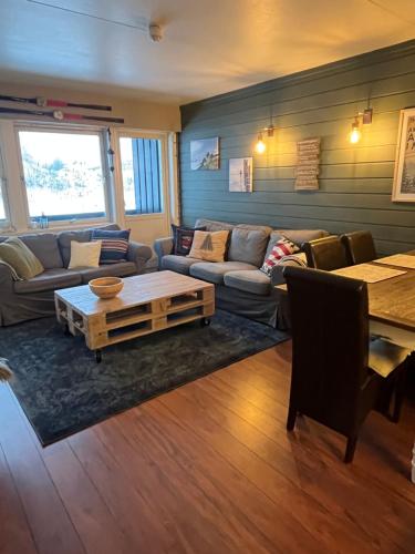 una sala de estar con un sofá y una mesa en Storehorn Apartments Hemsedal, en Hemsedal