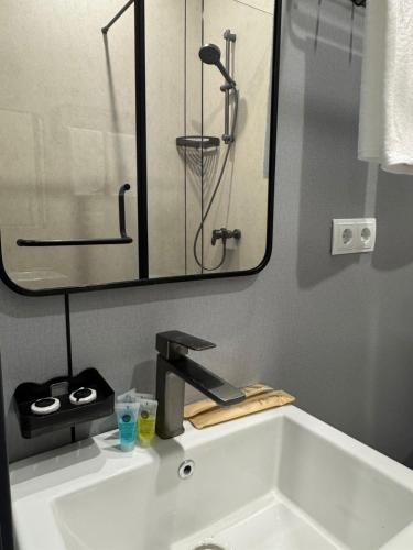 a bathroom sink with a faucet and a mirror at Home Inn Hotel in Almaty
