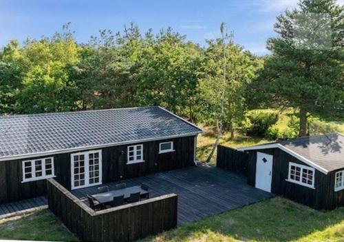 a small house with a deck in the yard at Beach House Near Sejerø Bay in Hønsinge