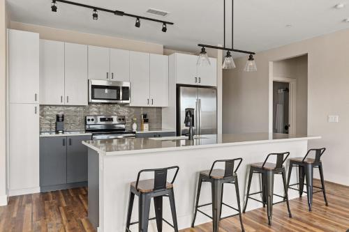 a kitchen with white cabinets and bar stools at Kasa Rino Denver in Denver