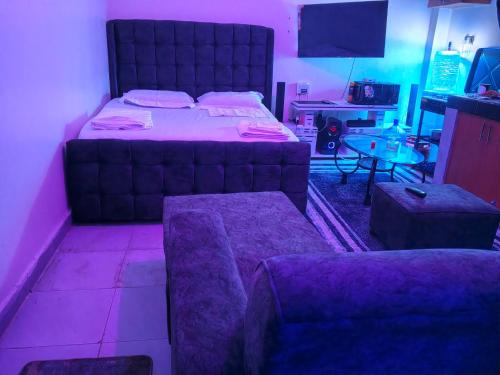 een slaapkamer met een bed, een bank en een tafel bij Goshen heights in Kitengela 