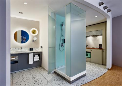 a bathroom with a shower and a sink at Four Points by Sheraton Munich Messe in Munich