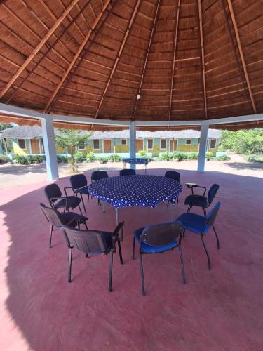 una mesa azul y sillas bajo un techo de madera en Catalyst Academy, en Sifoe