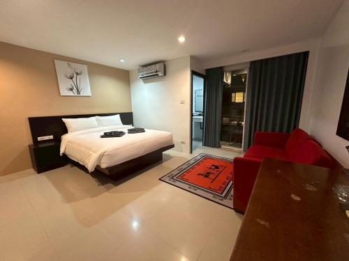 a bedroom with a bed and a red couch at Patong gray house in Patong Beach
