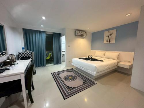 a bedroom with a bed and a desk and a sink at Patong gray house in Patong Beach