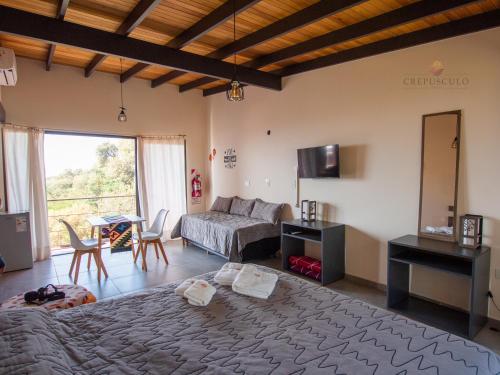 een woonkamer met een bed en een bank bij Crepúsculo Serrano in Merlo