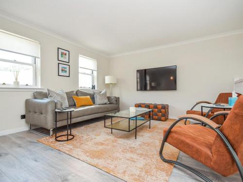 Una sala de estar con un sofá y un televisor. en The White House, en Callander