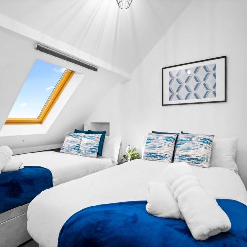 two beds in a room with a window at Modern Apartment - Accommodates 4 - On Street Parking - Neftlix 2CR in Birmingham