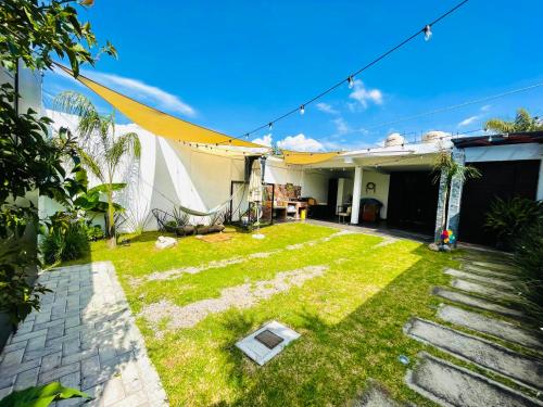 een kleine tuin met een gazon bij een huis bij Loft Industrial Petfriendly in Tlaxcala de Xicohténcatl