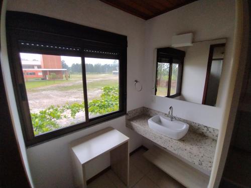 un bagno con un lavandino e una grande finestra di Pousada Divino Oleiro - Gov. Celso Ramos a Governador Celso Ramos