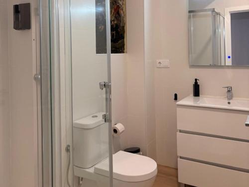 a bathroom with a toilet and a glass shower at Life Apartments Arcos 27 in Jerez de la Frontera