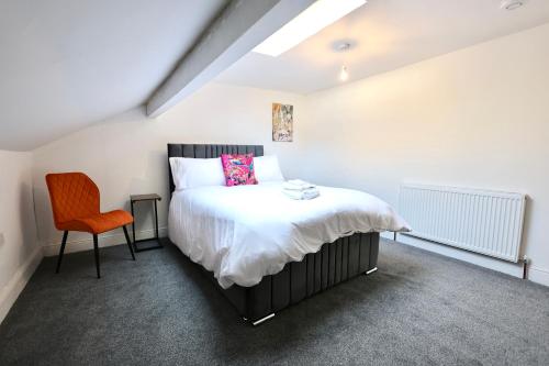 ein Schlafzimmer mit einem Bett und einem orangenen Stuhl in der Unterkunft Nursery House Retreat in Heptonstall