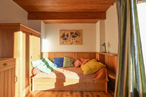 une chambre avec un lit en bois avec des oreillers colorés dans l'établissement Chalet Paisible, à Arc 1600