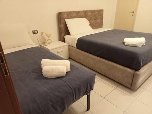 zwei Betten in einem Hotelzimmer mit Handtüchern darauf in der Unterkunft Villetta con Giardino by Rhospitality it in Rho