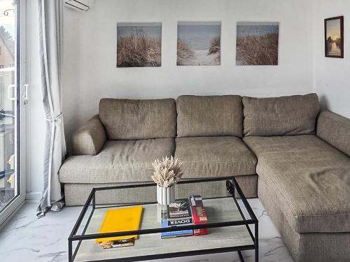 un soggiorno con un divano e un tavolo di vetro di Oasis a Hythe