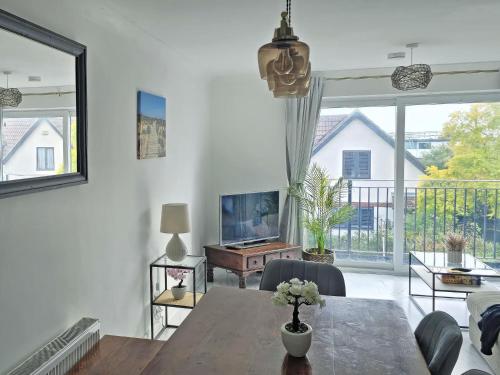 un soggiorno con un tavolo e una grande finestra di Oasis a Hythe